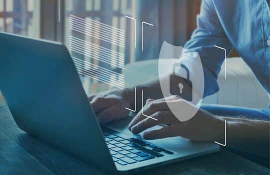 Man typing on laptop with fraud protection logo overlay