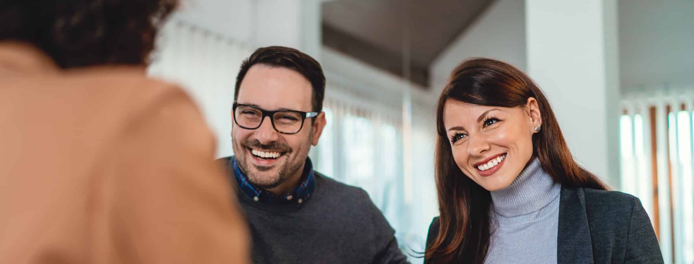 Couple signing documents with banker