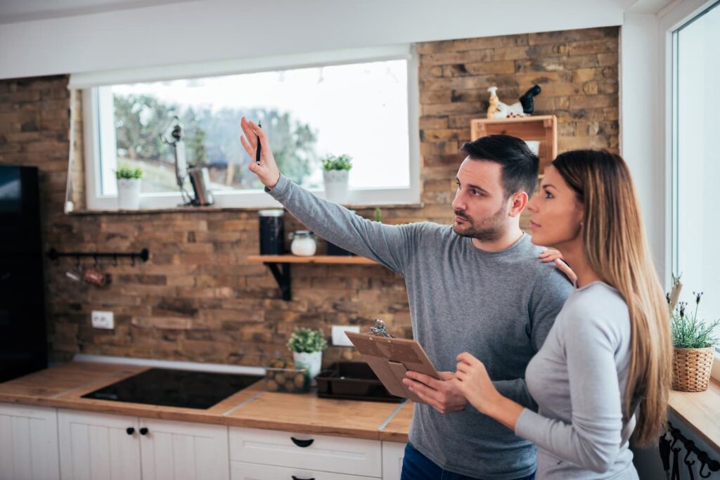 A couple make a list of home renovations in kitchen
